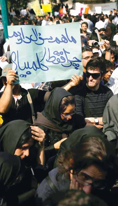 「われわれにも質問がある。なぜコロンビア大学でしか質問に答えようとしないのか」と書かれたプラカード