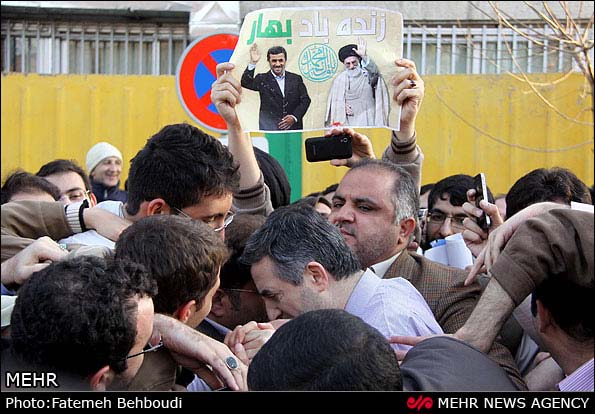 メフル通信からの転載。「春よ、永遠に」と書かれたポスターが見える。その下にいる色白の人物は、アフマディーネジャードの側近のマシャーイー。