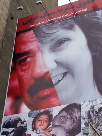 イラン国内に掲げられている看板。アシュトンとサッダーム・フセインの写真が組み合わされ、その下には化学兵器の犠牲者たちの写真が掲載されている。看板には「西洋流の人権」と書かれている。