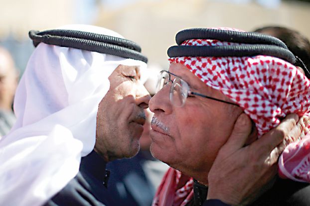 弔問客を迎えるカサースバ操縦士の父親（右）、昨日のカラク（ロイター）