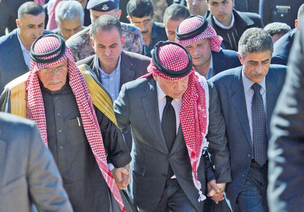 カサースバ操縦士の父親(左)と叔父の手を握るアブドゥッラー2世国王(AP)