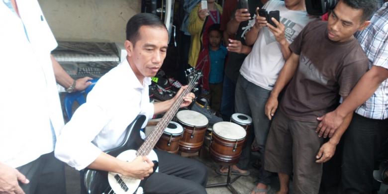 7月26日、中部ジャワ州ソロのノトハルジョ中古品市場でベースギターを試すジョコ・ウィドド次期大統領