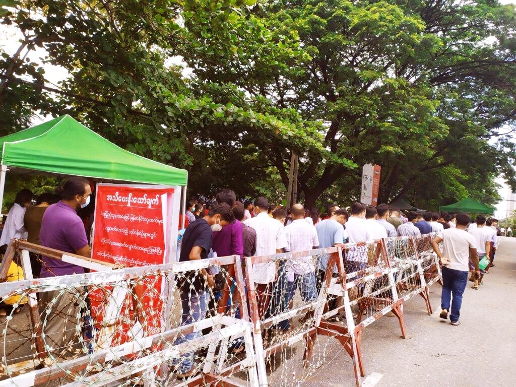 軍事クーデターの後、国内の困窮によって海外に行き仕事をするべく、パスポートを入手するために列に並ぶ人々